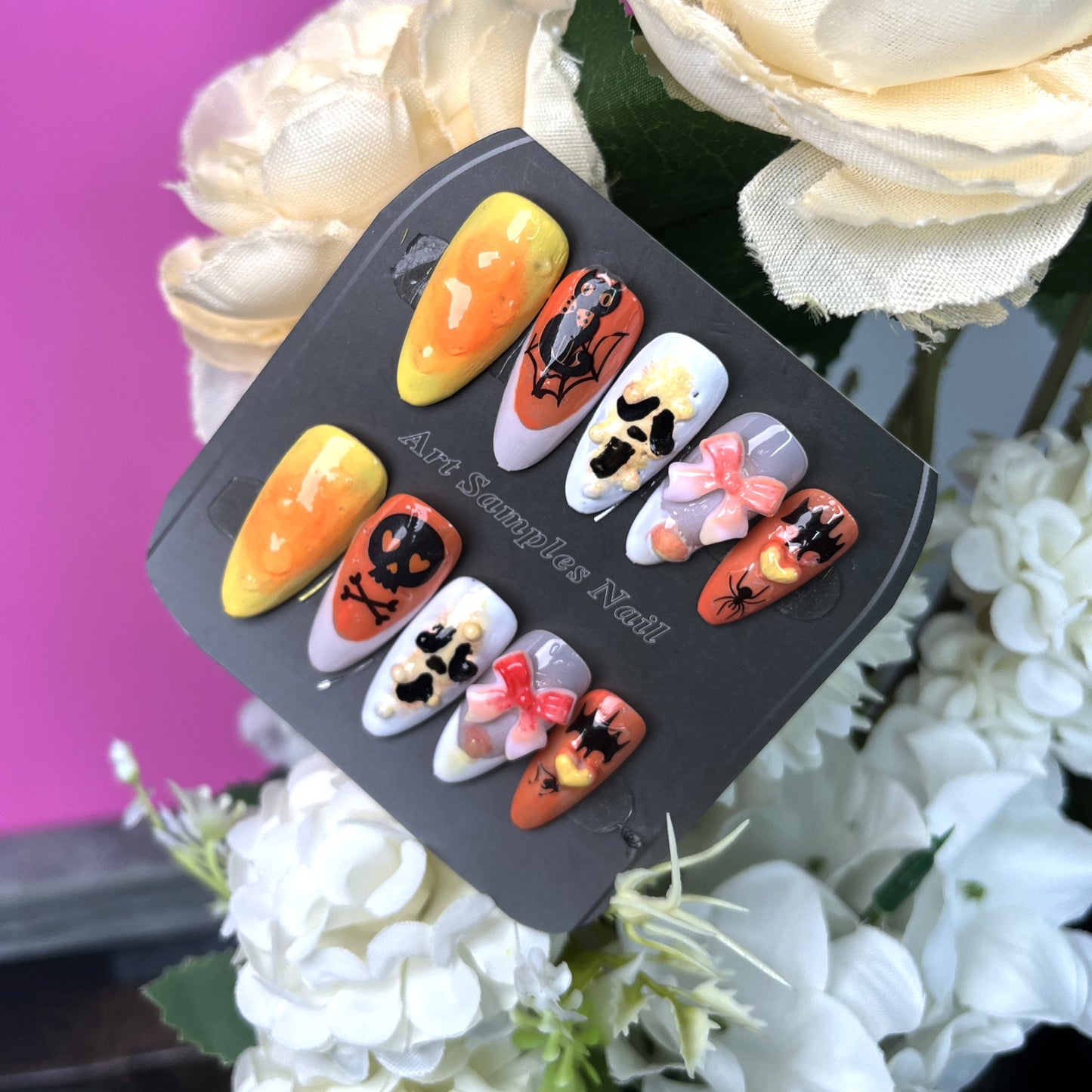 Halloween-themed nail art with skull, bat, and bow elements