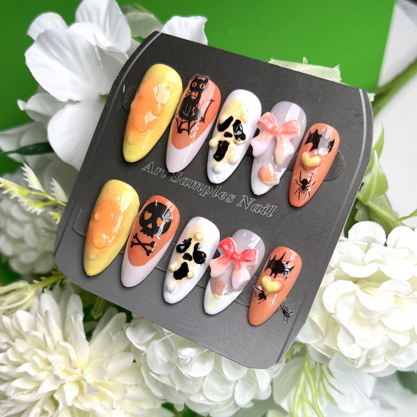 Halloween-themed nail art with skull, bat, and bow elements